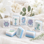 Set of decorative tiles with artistic designs on a white surface with flowers and leaves.