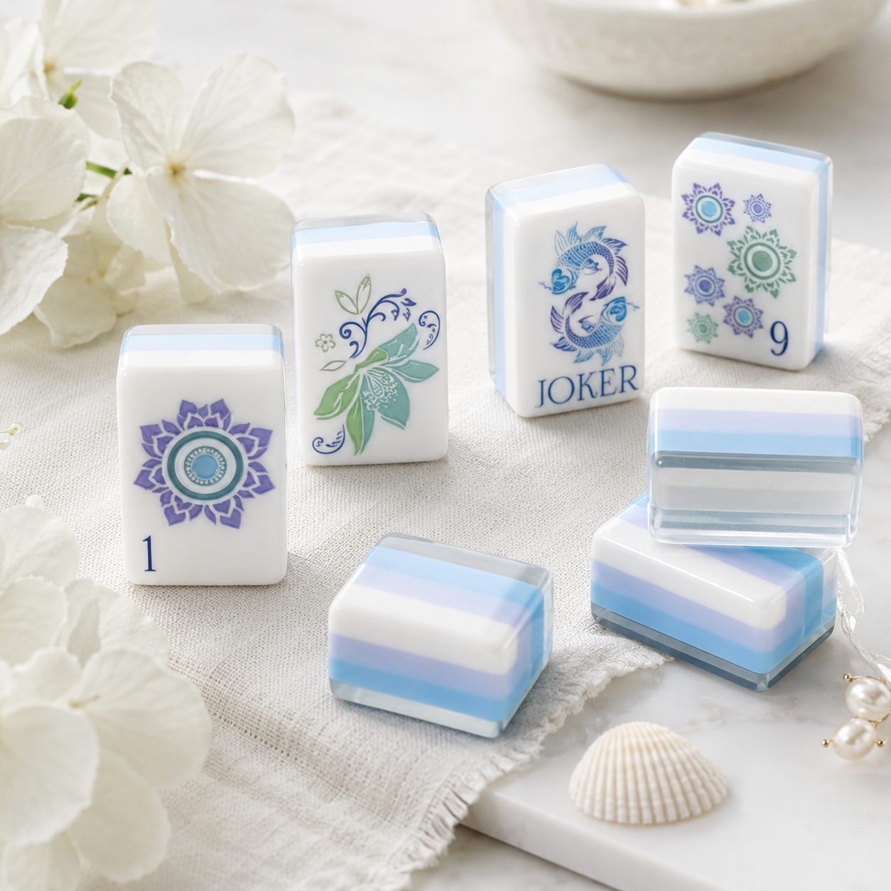 Close-up of acrylic Mahjong tiles with blue layered edges and lotus artwork