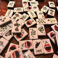 A gothic-inspired mahjong tile set made for Halloween game nights, dark fantasy collectors, and players who want a bold alternative to traditional mahjong tiles. The design includes snakes, skulls, vampire teeth, spiders, bats, roses, and gothic-style jokers on a soft pink tile base.