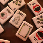 A gothic-inspired mahjong tile set made for Halloween game nights, dark fantasy collectors, and players who want a bold alternative to traditional mahjong tiles. The design includes snakes, skulls, vampire teeth, spiders, bats, roses, and gothic-style jokers on a soft pink tile base.